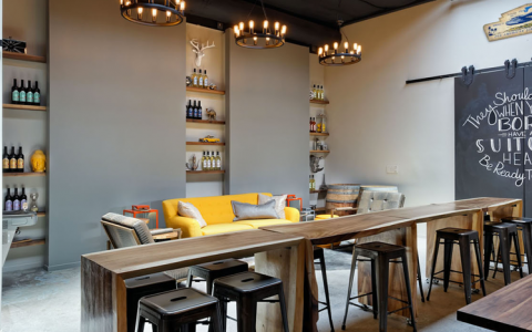 Flying Suitcase Winery sitting area has long wooden tables and tools and couched seating area
